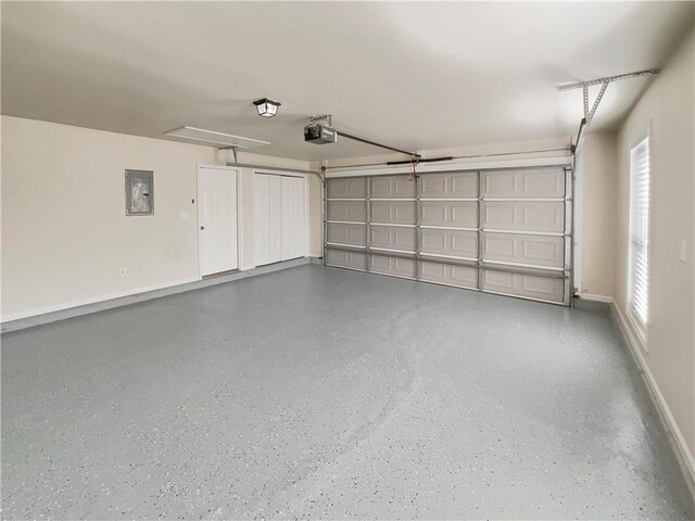 garage featuring baseboards, electric panel, and a garage door opener