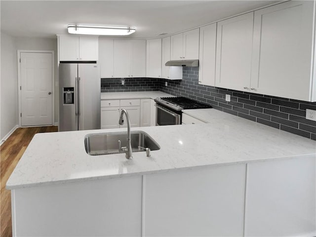 kitchen featuring stainless steel appliances, white cabinetry, a sink, and tasteful backsplash