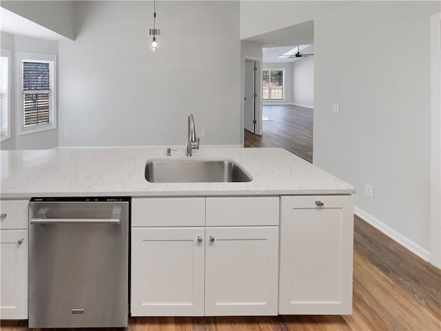 kitchen featuring dishwasher, light stone counters, a sink, and white cabinets