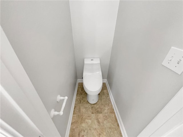 bathroom with baseboards and toilet