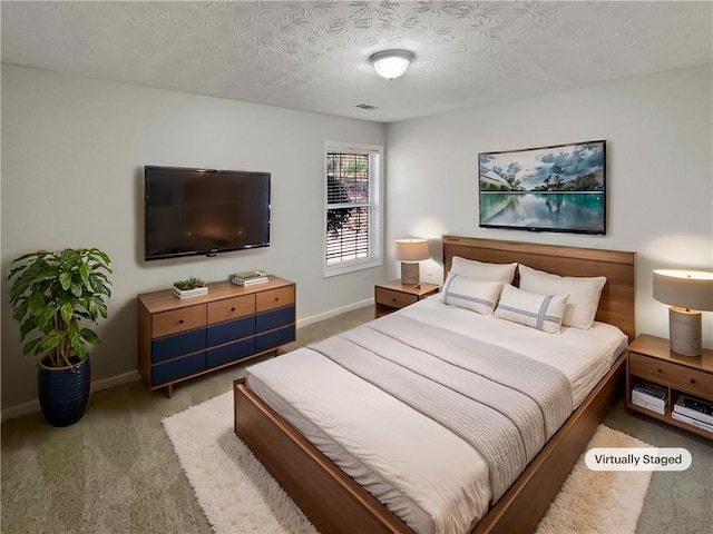 carpeted bedroom featuring a textured ceiling, visible vents, and baseboards