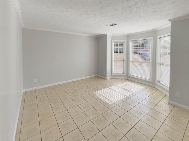 empty room featuring a textured ceiling, light tile patterned flooring, visible vents, baseboards, and crown molding