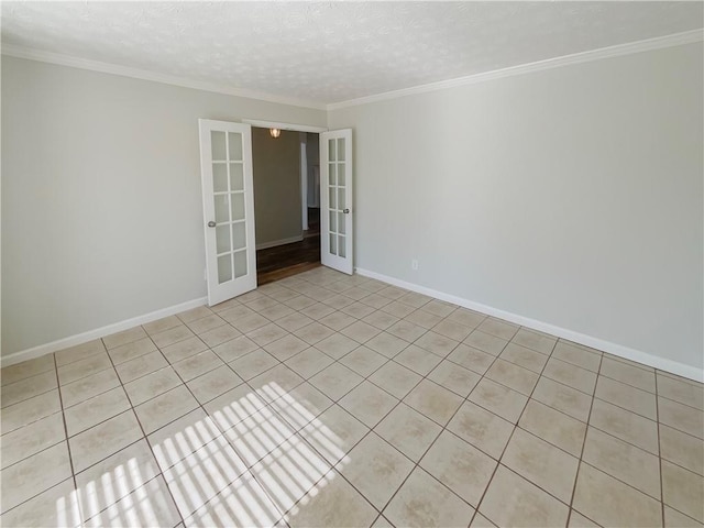 spare room with baseboards, ornamental molding, a textured ceiling, and french doors