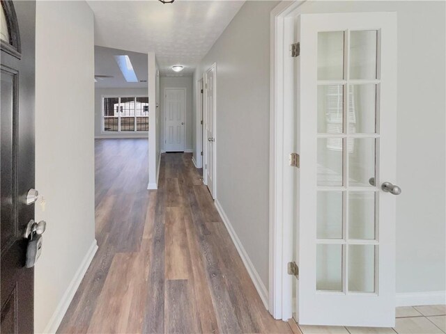 hall featuring baseboards and wood finished floors