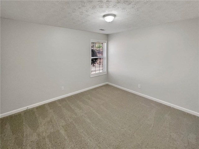 carpeted spare room featuring a textured ceiling, visible vents, and baseboards