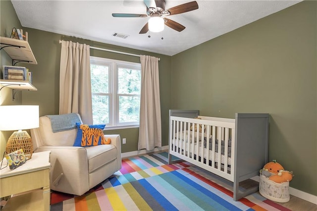 1867 N Creek Cir, Alpharetta, GA 30009 - bedroom featuring baseboards, a nursery area, wood finished floors, and ceiling fan