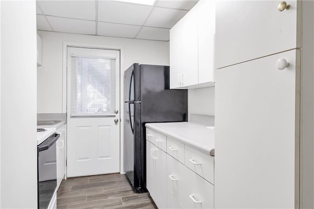 1867 N Creek Cir, Alpharetta, GA 30009 - kitchen with range with electric stovetop, white cabinets, light countertops, freestanding refrigerator, and wood finished floors