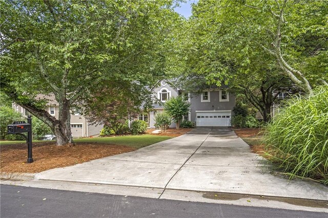1867 N Creek Cir, Alpharetta, GA 30009 - view of property hidden behind natural elements featuring an attached garage, driveway, and stucco siding
