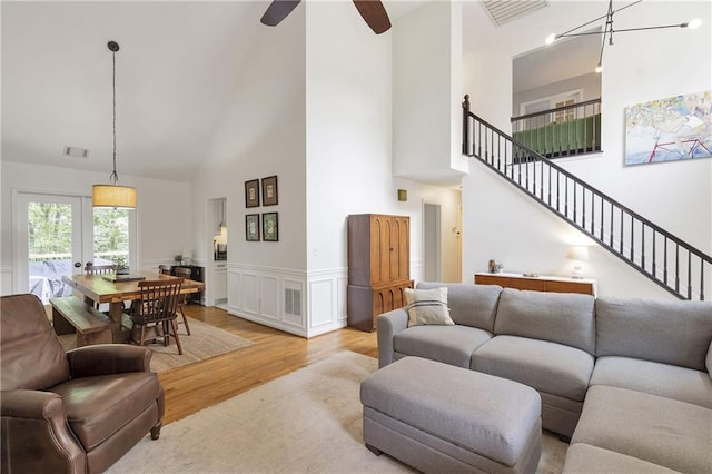 1867 N Creek Cir, Alpharetta, GA 30009 - living area featuring a towering ceiling, light wood-style floors, stairway, a wainscoted wall, and ceiling fan