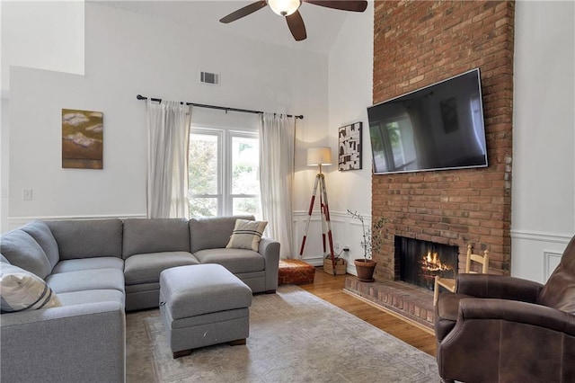 1867 N Creek Cir, Alpharetta, GA 30009 - living area featuring a fireplace, ceiling fan, a towering ceiling, and wood finished floors