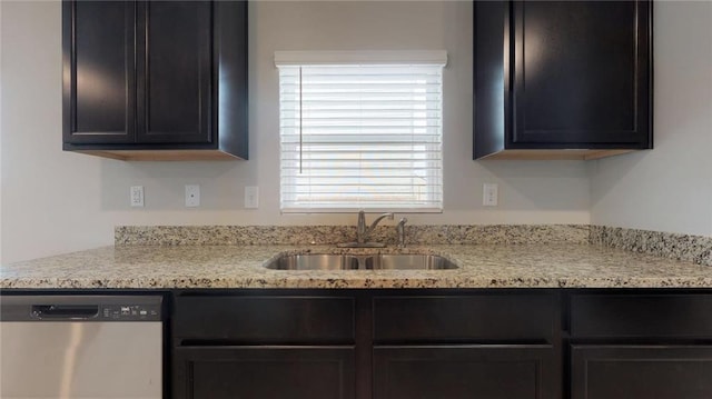 kitchen with a sink, stainless steel dishwasher, and light stone countertops
