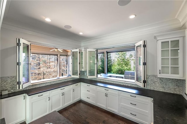 interior space featuring dark countertops, crown molding, and backsplash