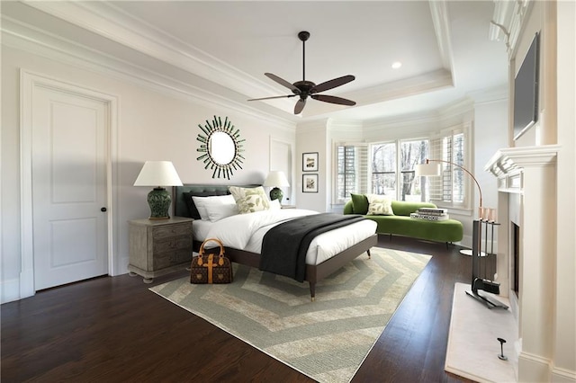 bedroom with dark wood-style floors, ornamental molding, a raised ceiling, and a ceiling fan