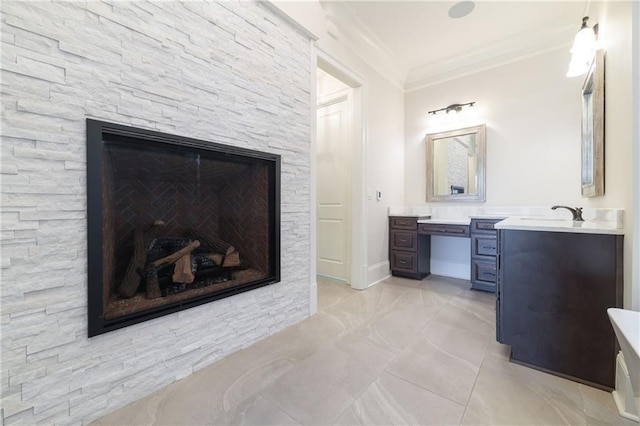 full bathroom with vanity, baseboards, crown molding, and a stone fireplace