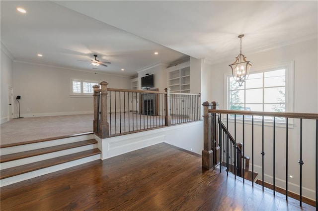 corridor featuring a chandelier, recessed lighting, wood finished floors, and crown molding