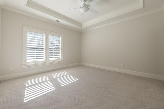 unfurnished room with light carpet, visible vents, a tray ceiling, and ornamental molding