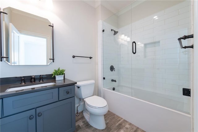 bathroom with shower / bath combination with glass door, vanity, toilet, and wood finished floors