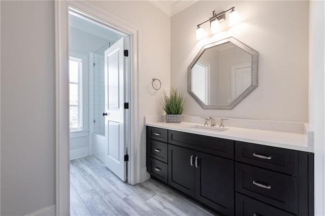 bathroom featuring baseboards, wood finished floors, and vanity