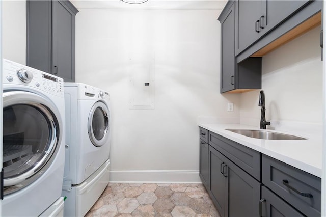 laundry area with cabinet space, electric panel, washer and dryer, and a sink