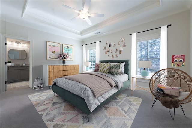 bedroom with multiple windows, visible vents, a raised ceiling, and carpet flooring