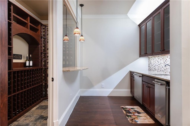 wine area with dark wood-style floors, crown molding, a sink, and baseboards