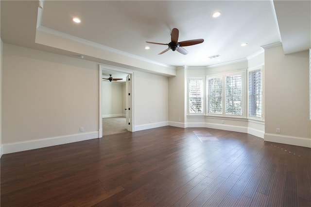 empty room featuring dark wood-style floors, baseboards, visible vents, and ornamental molding