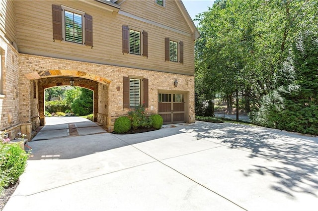 view of front of house featuring driveway and brick siding