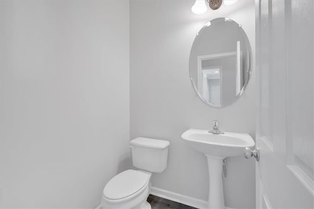 bathroom featuring hardwood / wood-style floors and toilet