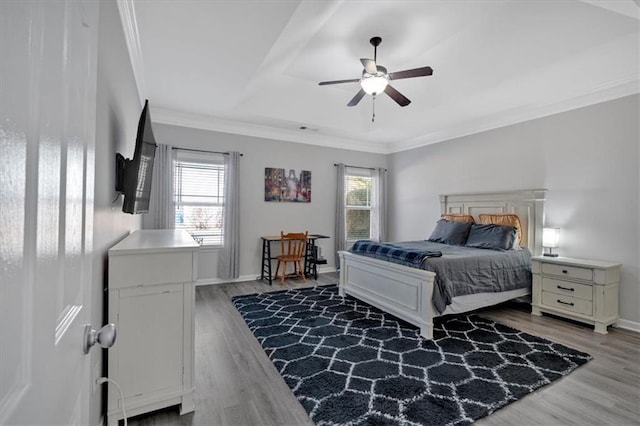 bedroom with hardwood / wood-style flooring, ornamental molding, multiple windows, and ceiling fan