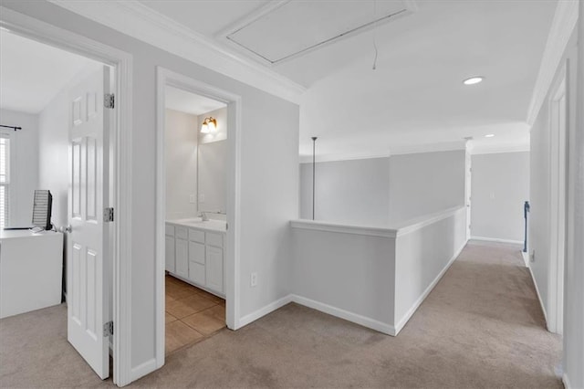 hallway featuring sink, crown molding, and light carpet