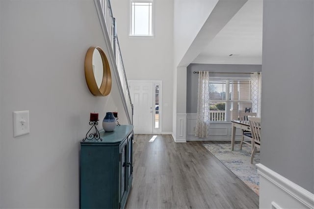 foyer featuring a towering ceiling and light hardwood / wood-style floors