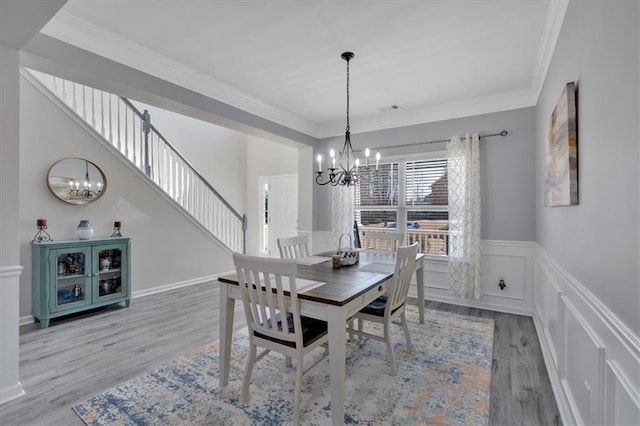 dining room with a notable chandelier, crown molding, and wood-type flooring