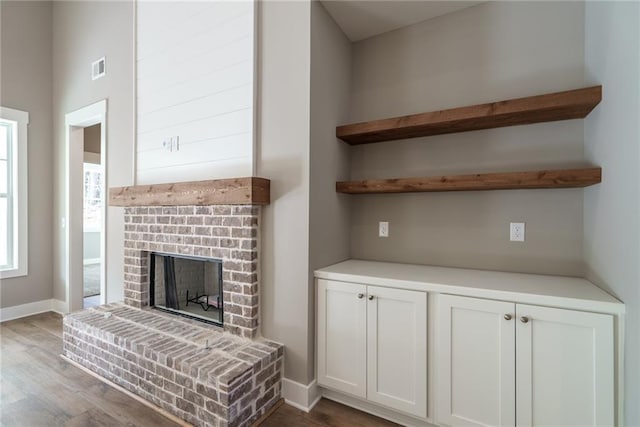 living room with light hardwood / wood-style flooring and a brick fireplace