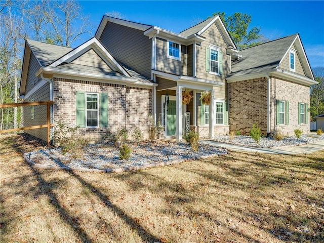 view of front of house featuring brick siding and a front yard