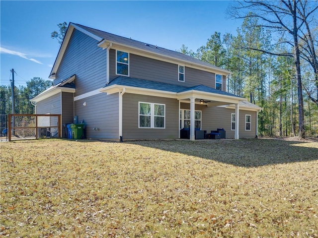 back of house featuring ceiling fan and a lawn