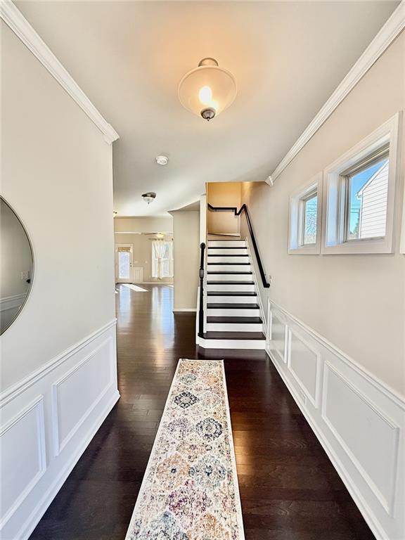 hall featuring ornamental molding and dark hardwood / wood-style floors