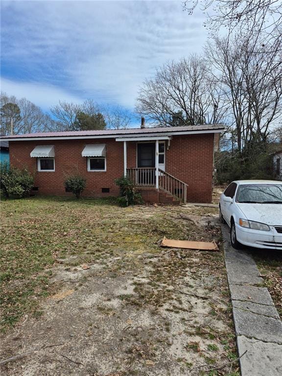 view of front of home with brick siding and crawl space