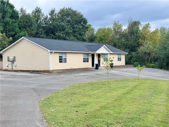 single story home with driveway and a front lawn