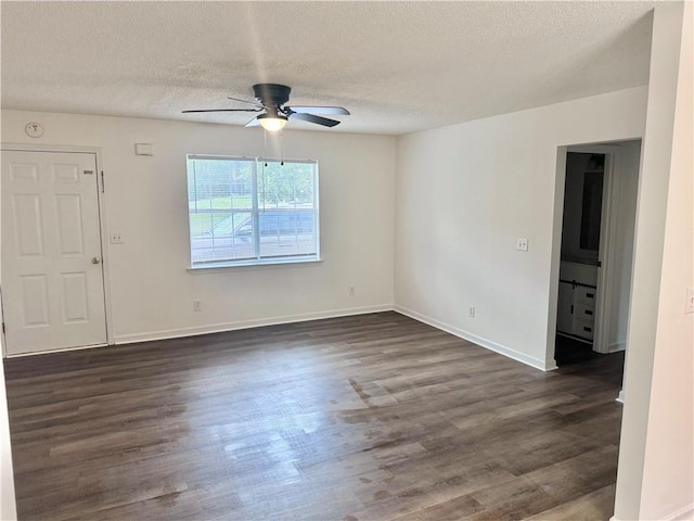 spare room featuring dark wood-style floors, baseboards, a textured ceiling, and a ceiling fan