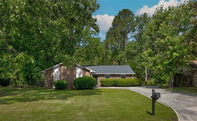 view of front of property with a front yard, driveway, and brick siding