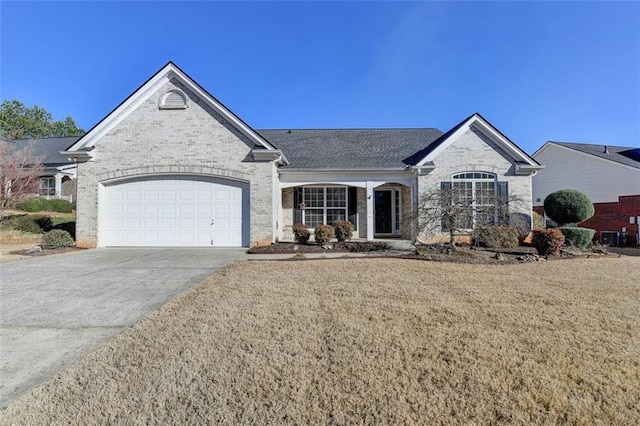 view of front of home with an attached garage, a front lawn, concrete driveway, and brick siding