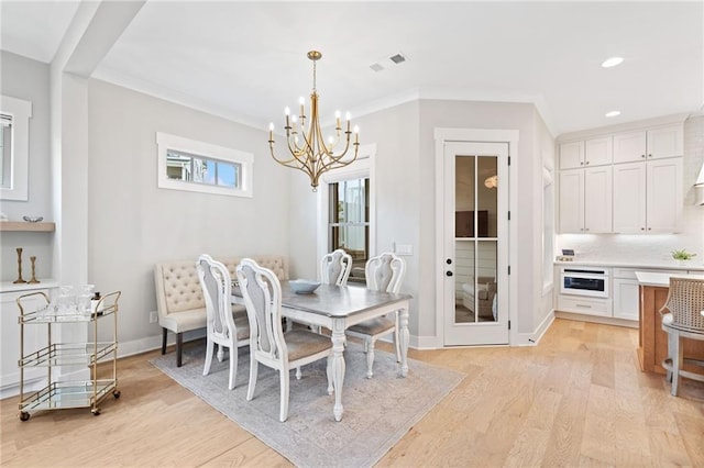 1010 Fendley St, Woodstock, GA 30188 - dining space with light wood finished floors, a chandelier, recessed lighting, crown molding, and baseboards