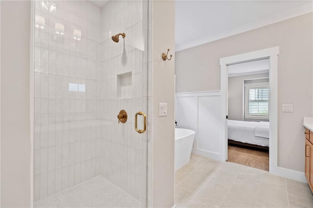 1010 Fendley St, Woodstock, GA 30188 - bathroom featuring vanity, a stall shower, a freestanding bath, tile patterned floors, and wainscoting