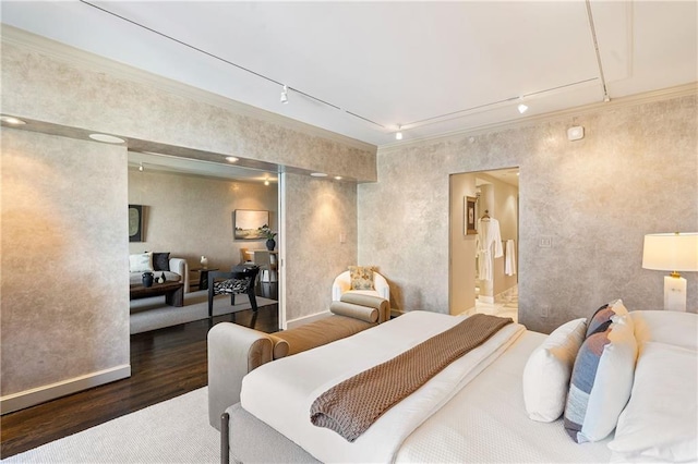 bedroom with dark wood-type flooring, track lighting, and ornamental molding