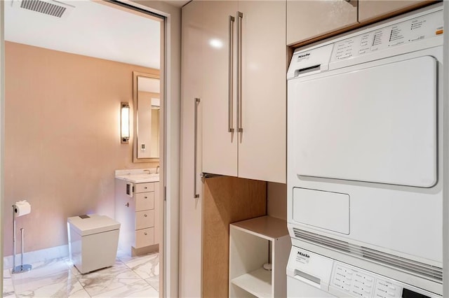 laundry area featuring stacked washer / dryer