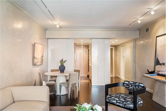 dining space with ornamental molding, dark hardwood / wood-style floors, and track lighting