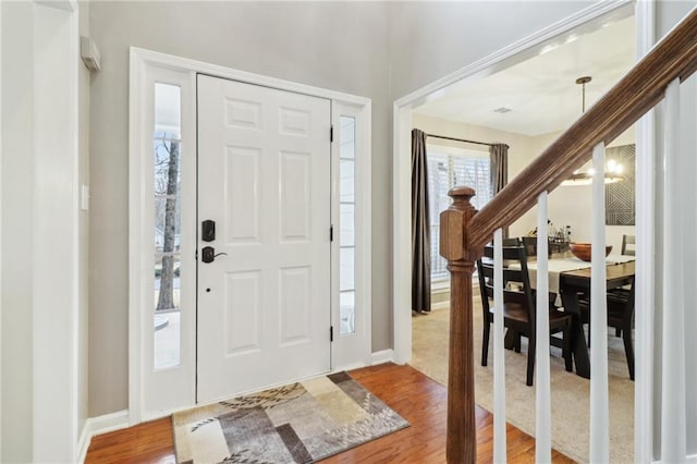 foyer entrance featuring a notable chandelier and wood-type flooring