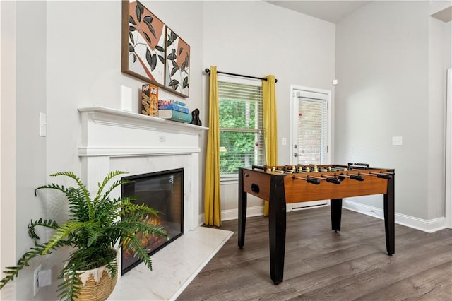 recreation room featuring a premium fireplace and dark hardwood / wood-style floors