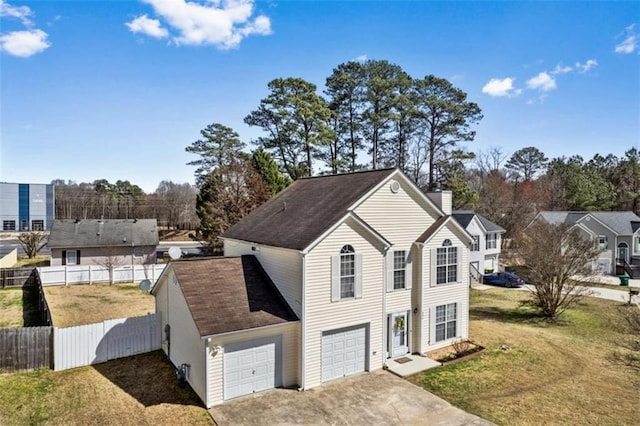 view of front of property with a chimney, concrete driveway, an attached garage, a front yard, and fence