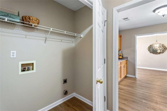 laundry room featuring light wood-type flooring, visible vents, electric dryer hookup, and baseboards